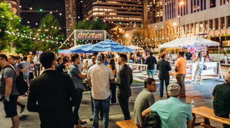 A crowd of Colorado Startup Week attendees standing and sitting in a courtyard, talking to each other.