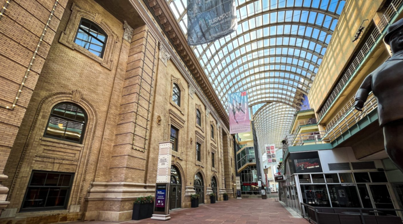 The Denver Performing Arts Complex’s covered Galleria walkway, with the Ellie Caulkins Opera House and Garner Galleria Theatre visible beneath the glass canopy.