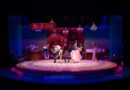 The cast of Destiny of Desire performs an energetic casino scene against a rose-covered backdrop with dramatic lighting and chandeliers.