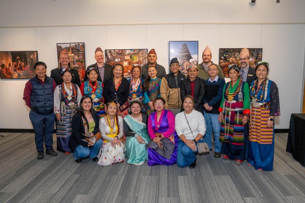 Colorado Nepalese Community members, artists, supporters and guests gather at the Museum of Boulder, with several attendees wearing traditional Nepali clothing and jewelry.