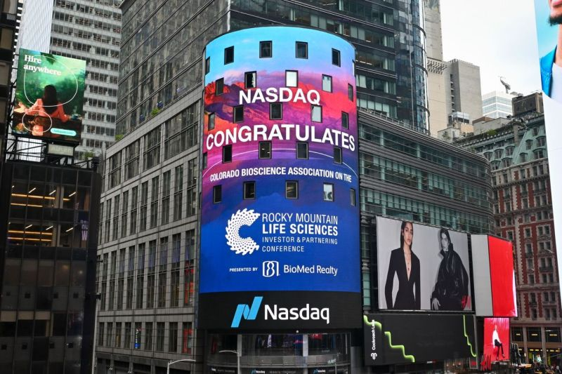 A Nasdaq digital billboard in Times Square congratulates the Colorado BioScience Association during the Rocky Mountain Life Sciences Investor & Partnering Conference, featuring colorful Colorado mountain imagery.