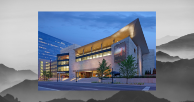 Exterior of the History Colorado Center in downtown Denver at dusk, featuring modern architecture, illuminated windows and a distinctive angular roofline.