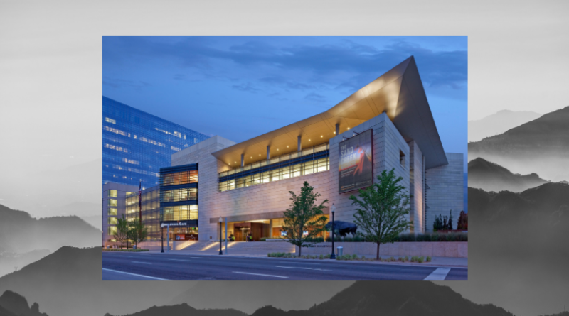 Exterior of the History Colorado Center in downtown Denver at dusk, featuring modern architecture, illuminated windows and a distinctive angular roofline.