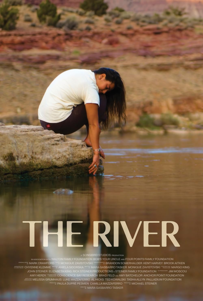 Poster for the documentary "The River," showing a woman sitting on a rock beside a river and reaching into the water, with a red rock landscape in the background.